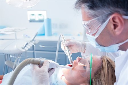 suzione - Dentist examining his patient with a suction hose at the dental clinic Fotografie stock - Microstock e Abbonamento, Codice: 400-07940755