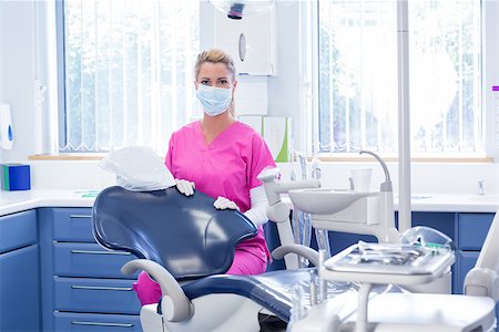 simsearch:400-07940798,k - Dentist in mask looking at camera beside chair at the dental clinic Stock Photo - Budget Royalty-Free & Subscription, Code: 400-07940774