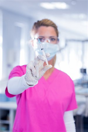 simsearch:400-07941465,k - Dentist in surgical mask and scrubs holding syring at the dental clinic Stock Photo - Budget Royalty-Free & Subscription, Code: 400-07940794