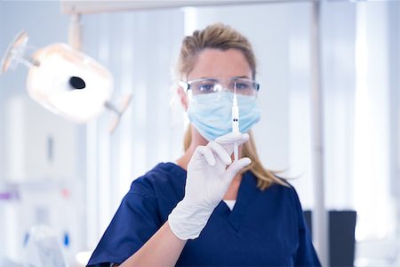 simsearch:400-07938947,k - Dentist in mask and glove holding an injection at the dental clinic Photographie de stock - Aubaine LD & Abonnement, Code: 400-07940795