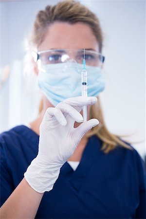 simsearch:400-07938947,k - Dentist in mask and glove holding an injection at the dental clinic Photographie de stock - Aubaine LD & Abonnement, Code: 400-07940796