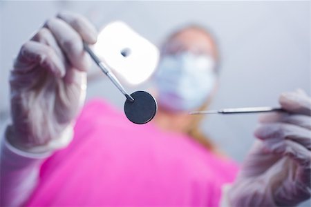 simsearch:400-07941465,k - Dentist in surgical mask holding tools over patient at the dental clinic Stock Photo - Budget Royalty-Free & Subscription, Code: 400-07940790