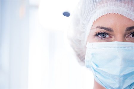 simsearch:400-07940798,k - Dentist in surgical mask and cap looking at camera at the dental clinic Stock Photo - Budget Royalty-Free & Subscription, Code: 400-07940804