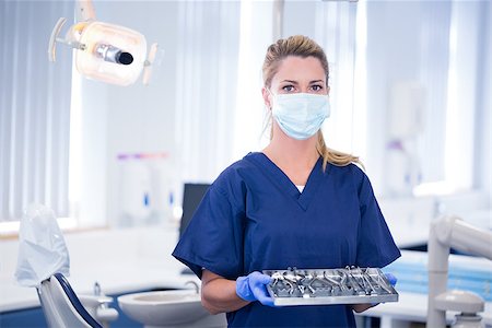 simsearch:400-07940798,k - Dentist in mask holding tray of tools at the dental clinic Stock Photo - Budget Royalty-Free & Subscription, Code: 400-07940805