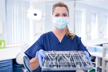 simsearch:400-07940798,k - Dentist in blue scrubs holding tray of tools at the dental clinic Stock Photo - Budget Royalty-Free & Subscription, Code: 400-07940806