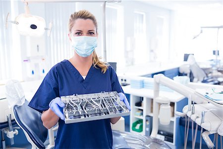 simsearch:400-07941454,k - Dentist in blue scrubs holding tray of tools at the dental clinic Stockbilder - Microstock & Abonnement, Bildnummer: 400-07940808