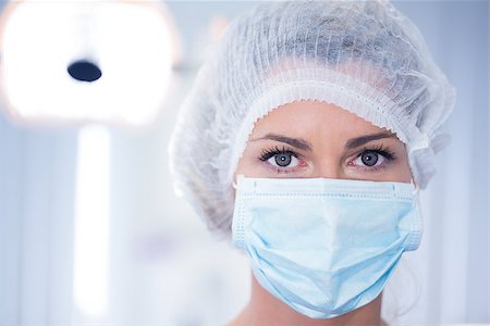 simsearch:400-07938947,k - Dentist in surgical mask and cap looking at camera at the dental clinic Photographie de stock - Aubaine LD & Abonnement, Code: 400-07940803