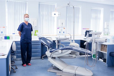 simsearch:400-07940798,k - Dentist in blue scrubs standing beside chair at the dental clinic Stock Photo - Budget Royalty-Free & Subscription, Code: 400-07940819