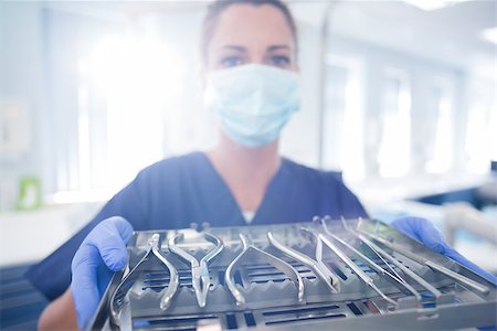 dentist tray - Dentist in blue scrubs showing tray of tools at the dental clinic Stock Photo - Budget Royalty-Free & Subscription, Code: 400-07940811