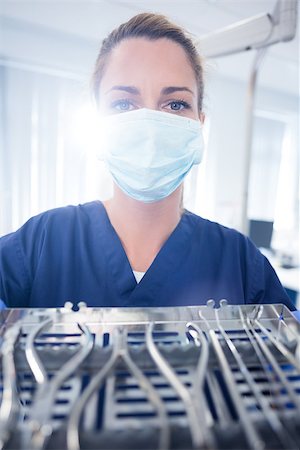 dentist tray - Dentist in blue scrubs showing tray of tools at the dental clinic Stock Photo - Budget Royalty-Free & Subscription, Code: 400-07940812