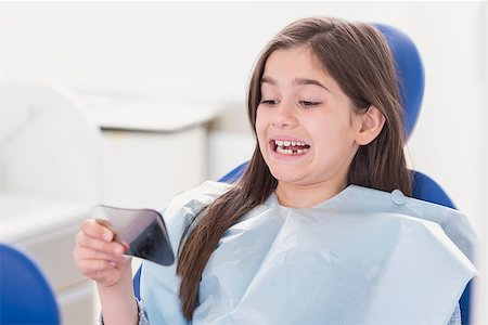 Young patient looking in the mirror in dental clinic Stock Photo - Budget Royalty-Free & Subscription, Code: 400-07941406