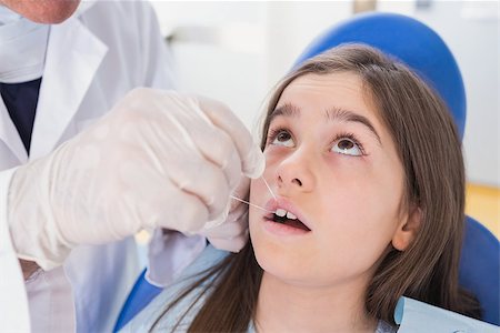 dentist bib girl - Pediatric dentist using dental floss to his young patient in dental clinic Photographie de stock - Aubaine LD & Abonnement, Code: 400-07941408