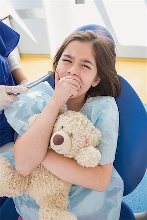 dentist bib girl - Scared patient covering mouth and holding teddy bear in dental clinic Stock Photo - Budget Royalty-Free & Subscription, Code: 400-07941415