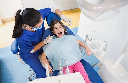 dentist bib girl - Pediatric dentist examining her patient with mouth open in dental clinic Stock Photo - Budget Royalty-Free & Subscription, Code: 400-07941416