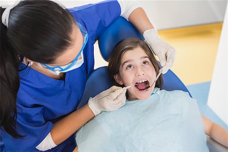 dentist bib girl - Pediatric dentist examining her patient with mouth open in dental clinic Stock Photo - Budget Royalty-Free & Subscription, Code: 400-07941417