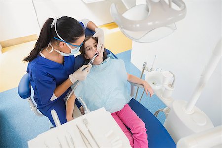 dentist bib girl - High angle view of pediatric dentist examining her young patient in dental clinic Stock Photo - Budget Royalty-Free & Subscription, Code: 400-07941418