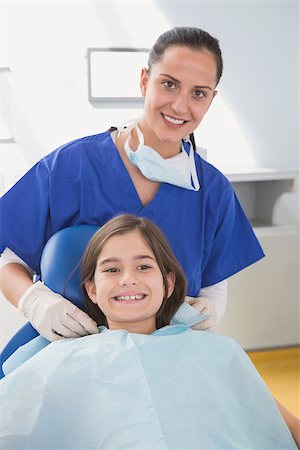 dentist bib girl - Pediatric dentist putting on her young patient the scrubs in dental clinic Stock Photo - Budget Royalty-Free & Subscription, Code: 400-07941411