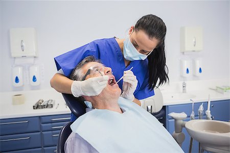 female with dental tools at work - Dentist examining a patient with tools in dental clinic Stock Photo - Budget Royalty-Free & Subscription, Code: 400-07941445