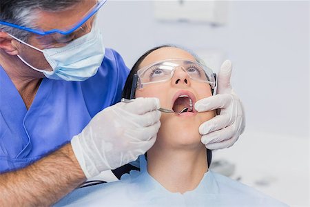 female with dental tools at work - Dentist examining a patient with angle mirror in dental clinic Stock Photo - Budget Royalty-Free & Subscription, Code: 400-07941489