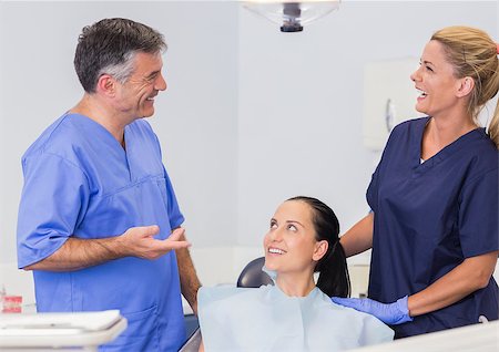 dentist patient talking - Smiling dentist and nurse speaking with their patient in dental clinic Stock Photo - Budget Royalty-Free & Subscription, Code: 400-07941503