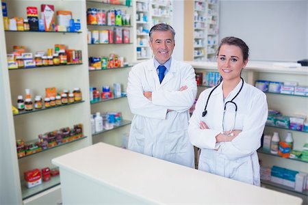 Smiling pharmacist and his trainee with arms crossed in the pharmacy Stock Photo - Budget Royalty-Free & Subscription, Code: 400-07941532