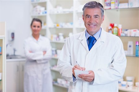Pharmacist and his trainee with arms crossed behind in the pharmacy Stock Photo - Budget Royalty-Free & Subscription, Code: 400-07941541