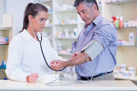 Trainee listening to patients pulse with stethoscope in the pharmacy Stock Photo - Budget Royalty-Free & Subscription, Code: 400-07941615