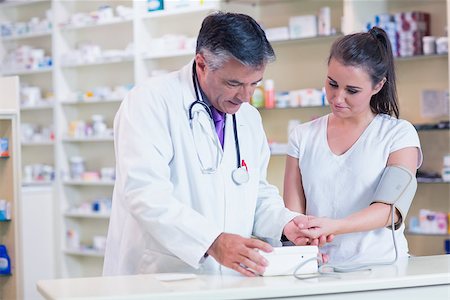 pharmacist talking client - Pharmacist showing blood pressure of his patient to her in the pharmacy Stock Photo - Budget Royalty-Free & Subscription, Code: 400-07941620