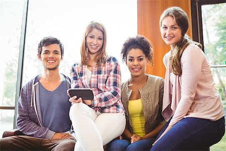 simsearch:630-06724589,k - Happy students sitting on a sofa using mobile phone at the university Stock Photo - Budget Royalty-Free & Subscription, Code: 400-07941779