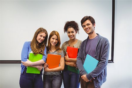 Students standing and smiling at camera holding notepads in classroom Stock Photo - Budget Royalty-Free & Subscription, Code: 400-07941822