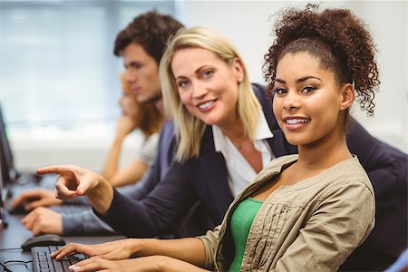 simsearch:400-07267978,k - Cheerful teacher and student looking at camera in the computer room Stock Photo - Budget Royalty-Free & Subscription, Code: 400-07941878