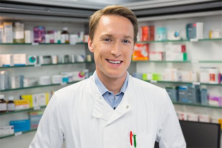 Handsome pharmacist smiling at camera at the hospital pharmacy Stock Photo - Budget Royalty-Free & Subscription, Code: 400-07941886