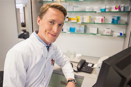 Happy pharmacist using the computer at the hospital pharmacy Stock Photo - Budget Royalty-Free & Subscription, Code: 400-07941901