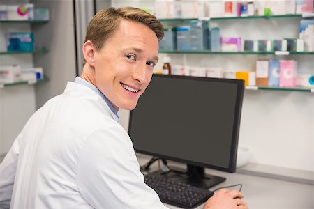 Happy pharmacist using the computer at the hospital pharmacy Stock Photo - Budget Royalty-Free & Subscription, Code: 400-07941902