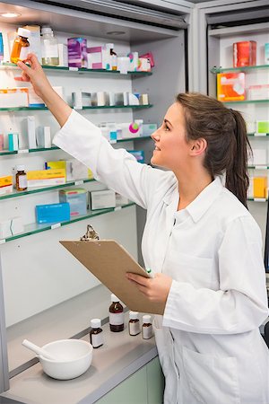 simsearch:6109-08537870,k - Junior pharmacist taking medicine from shelf at the hospital pharmacy Stock Photo - Budget Royalty-Free & Subscription, Code: 400-07941983
