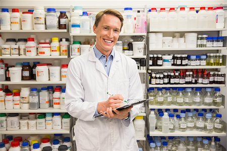 simsearch:6109-08537870,k - Handsome pharmacist smiling at camera at the hospital pharmacy Stock Photo - Budget Royalty-Free & Subscription, Code: 400-07942016