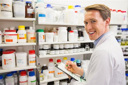 simsearch:6109-08537870,k - Handsome pharmacist writing on clipboard at the hospital pharmacy Stock Photo - Budget Royalty-Free & Subscription, Code: 400-07942018