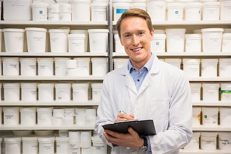 simsearch:6109-08537870,k - Handsome pharmacist writing on clipboard at the hospital pharmacy Stock Photo - Budget Royalty-Free & Subscription, Code: 400-07942023