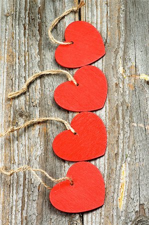 Four Red Hearts with Ropes In a Row on Rustic Wooden background Stock Photo - Budget Royalty-Free & Subscription, Code: 400-07954157