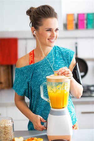 smoothie sports - Happy fitness young woman making pumpkin smoothie in kitchen Stock Photo - Budget Royalty-Free & Subscription, Code: 400-07955796