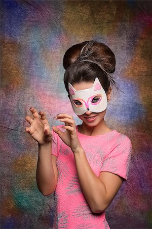 pretty brunette with creative hair-style and pink t-shirt posing with funny cat mask and pose. carnival concept Stock Photo - Budget Royalty-Free & Subscription, Code: 400-07955873