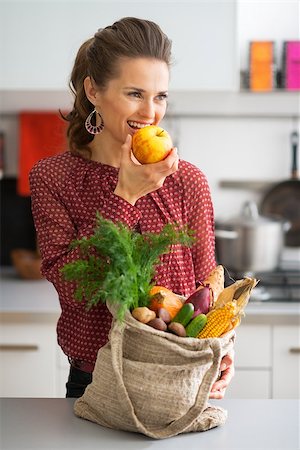 shopping bags in kitchen - Young housewife with purchases from local market eating apple Stock Photo - Budget Royalty-Free & Subscription, Code: 400-07955978