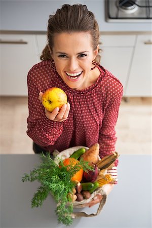 shopping bags in kitchen - Portrait of happy young housewife with purchases from local market holding apple Stock Photo - Budget Royalty-Free & Subscription, Code: 400-07955982