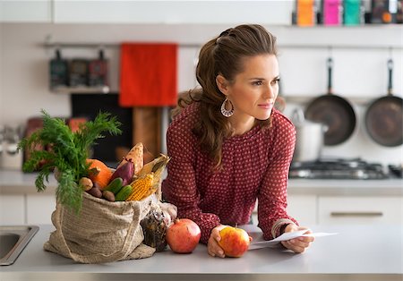 shopping bags in kitchen - Portrait of young housewife with checks after grocery shopping Stock Photo - Budget Royalty-Free & Subscription, Code: 400-07955991