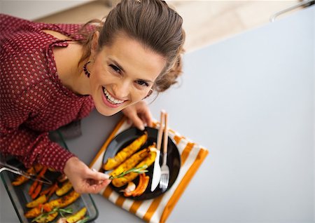 simsearch:400-08336563,k - Portrait of happy young housewife serving baked pumpkin Foto de stock - Royalty-Free Super Valor e Assinatura, Número: 400-07956036