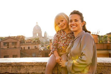 simsearch:400-07956611,k - Portrait of happy mother and baby girl on street overlooking rooftops of rome on sunset Foto de stock - Royalty-Free Super Valor e Assinatura, Número: 400-07956179