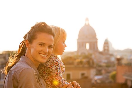 simsearch:400-07956611,k - Portrait of happy mother and baby girl on street overlooking rooftops of rome on sunset Foto de stock - Royalty-Free Super Valor e Assinatura, Número: 400-07956187