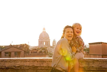 simsearch:400-07956611,k - Portrait of smiling mother and baby girl on street overlooking rooftops of rome on sunset Foto de stock - Royalty-Free Super Valor e Assinatura, Número: 400-07956183