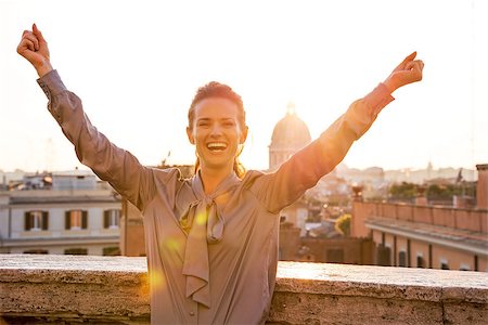 simsearch:400-07956611,k - Happy young woman rejoicing on street overlooking rooftops of rome on sunset Foto de stock - Royalty-Free Super Valor e Assinatura, Número: 400-07956196