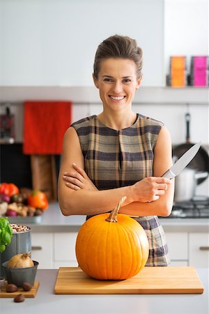 simsearch:400-07956836,k - Portrait of happy young housewife with pumpkin in kitchen Foto de stock - Royalty-Free Super Valor e Assinatura, Número: 400-07956526